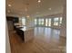 Open-concept kitchen and living room with hardwood flooring, many windows and a kitchen island at 13279 Arnold Palmer Cir # 867, Lancaster, SC 29720