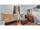 Cozy Bedroom featuring a wooden crib, comfortable seating, and charming woodland-themed wallpaper at 140 Hazelwood Dr, Rockwell, NC 28138