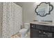 Bright bathroom featuring a polka dot shower curtain and decorative framed mirror above a vanity sink at 14010 Promenade Dr, Huntersville, NC 28078