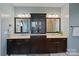 Double vanity bathroom with dark cabinets, mirrors, and tile flooring at 14010 Promenade Dr, Huntersville, NC 28078