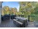 Outdoor dining deck features a table, grill and bench seating overlooking a wooded yard at 14010 Promenade Dr, Huntersville, NC 28078
