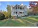 Charming two-story home boasting a double porch, stone accents, and a well-manicured lawn at 14010 Promenade Dr, Huntersville, NC 28078