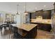 Gourmet kitchen with a granite island, dark wood cabinets, and stainless steel appliances at 14010 Promenade Dr, Huntersville, NC 28078