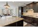 Modern kitchen featuring dark wood cabinetry, granite countertops, stainless steel appliances, and ample lighting at 14010 Promenade Dr, Huntersville, NC 28078