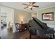 Inviting living room featuring an open archway, hardwood floors, and a grand piano at 14010 Promenade Dr, Huntersville, NC 28078