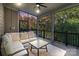 Inviting screened porch featuring comfortable seating, a coffee table, and scenic views of the surrounding landscape at 14010 Promenade Dr, Huntersville, NC 28078