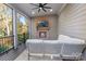 Cozy screened porch with a stone fireplace, a mounted TV, comfortable seating, and an amazing outdoor view at 14010 Promenade Dr, Huntersville, NC 28078