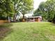 Lush backyard featuring a spacious lawn, shed, and patio area at 1408 Wicker Dr, Charlotte, NC 28210