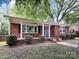Charming brick home with a well-maintained lawn, blue door and inviting curb appeal at 1408 Wicker Dr, Charlotte, NC 28210