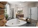 Luxurious stone-accented bathtub and vanity provide a spa-like experience in this modern bathroom at 14130 Lea Point Ct, Huntersville, NC 28078
