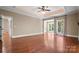 Large bedroom with hardwood floors, a tray ceiling, and plenty of natural light from large windows at 14130 Lea Point Ct, Huntersville, NC 28078