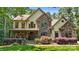 Charming two-story home with a stone facade, lush landscaping, and a covered front porch at 14130 Lea Point Ct, Huntersville, NC 28078