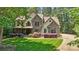 View of a two-story home with stone details, manicured lawn, and landscaping at 14130 Lea Point Ct, Huntersville, NC 28078