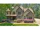 Beautiful two-story home with a stone facade, manicured lawn, and lush landscaping at 14130 Lea Point Ct, Huntersville, NC 28078