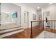 Hallway leading to a bedroom and bathroom featuring hardwood floors and decorative railings at 14130 Lea Point Ct, Huntersville, NC 28078