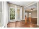 Bright living room with hardwood floors, large windows, and an open doorway to a dining area at 14130 Lea Point Ct, Huntersville, NC 28078