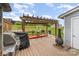 Outdoor deck featuring grill, pergola, chiminea, and table set with a scenic view of a grassy lawn at 1424 River Dr, Belmont, NC 28012