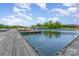 Dock with boats, boat slips, and a scenic lake view surrounded by lush greenery at 1424 River Dr, Belmont, NC 28012