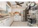 Kitchen featuring white cabinets, tiled floor and backsplash, and stainless steel refrigerator at 1424 River Dr, Belmont, NC 28012