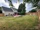 Large backyard with a lush lawn, wooden fence, pool and patio area, and outdoor furniture at 15003 Jerpoint Abby Dr, Charlotte, NC 28273
