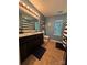 Stylish bathroom featuring a double sink vanity, large mirror with lighting, and a tub/shower with a striped curtain at 15003 Jerpoint Abby Dr, Charlotte, NC 28273