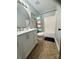 Bright bathroom featuring a white vanity, round mirror and tub with colorful striped curtain at 15003 Jerpoint Abby Dr, Charlotte, NC 28273