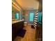 Well-lit bathroom with a dark vanity, stylish mirror, and a shower with a blue and white striped curtain at 15003 Jerpoint Abby Dr, Charlotte, NC 28273