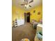 Bright yellow Bedroom featuring a changing table, glider and ceiling fan at 15003 Jerpoint Abby Dr, Charlotte, NC 28273