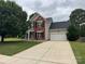 Charming two-story home featuring a well-manicured lawn and a classic brick and siding facade at 15003 Jerpoint Abby Dr, Charlotte, NC 28273