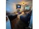Cozy living room with a fireplace, large TV, plush seating, and hardwood floors at 15003 Jerpoint Abby Dr, Charlotte, NC 28273