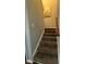 Carpeted staircase with wooden handrail and white trim, providing access to the upper levels of the home at 15003 Jerpoint Abby Dr, Charlotte, NC 28273
