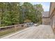 Expansive wooden deck with metal railings overlooking a serene wooded area and inground pool at 15906 Youngblood Rd, Charlotte, NC 28278