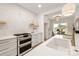Modern white kitchen features updated appliances, marbled counters, tile backsplash, and an eat-in dining area at 15906 Youngblood Rd, Charlotte, NC 28278