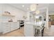 Modern white kitchen with stainless steel appliances, a center island, and stylish pendant lighting at 15906 Youngblood Rd, Charlotte, NC 28278