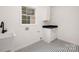The laundry room is equipped with a utility sink, storage cabinet, and a window for natural light at 15906 Youngblood Rd, Charlotte, NC 28278
