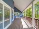 Long, covered back porch with wooden floorboards and views of the wooded surroundings at 16149 Haroa Ct, Tega Cay, SC 29708