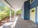 Inviting covered porch with wooden flooring, white support columns, and a bright yellow front door at 16149 Haroa Ct, Tega Cay, SC 29708
