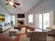 Bright living room with hardwood floors, a stone fireplace, and sliding glass doors to the deck at 16149 Haroa Ct, Tega Cay, SC 29708