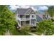 An aerial view of a charming two-story home with double porches nestled amongst lush greenery at 19034 Cypress Garden Dr, Davidson, NC 28036