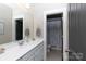 Well-lit bathroom features a vanity with sink, a large mirror, and a separate toilet area with a floral shower curtain at 19034 Cypress Garden Dr, Davidson, NC 28036