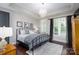 Bedroom features a chandelier, a large window, and a comfortable-looking bed at 19034 Cypress Garden Dr, Davidson, NC 28036