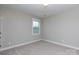Clean, simple bedroom with neutral paint, a window for natural light, and carpet flooring at 19034 Cypress Garden Dr, Davidson, NC 28036