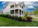 Inviting home exterior featuring a double porch, lush landscaping, and manicured lawn at 19034 Cypress Garden Dr, Davidson, NC 28036