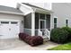 A garage and screened-in porch provide shade beside manicured landscaping at 19034 Cypress Garden Dr, Davidson, NC 28036