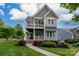 Charming two-story home with a double porch, landscaped yard, and inviting curb appeal on a sunny day at 19034 Cypress Garden Dr, Davidson, NC 28036