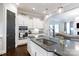 Elegant kitchen island with stone countertops, a stainless sink, and white cabinets at 19034 Cypress Garden Dr, Davidson, NC 28036