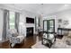 Cozy living room with a fireplace, dark hardwood flooring, and large windows at 19034 Cypress Garden Dr, Davidson, NC 28036