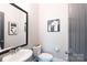 Stylish powder room features a pedestal sink, a mirror, toilet, and artwork on the neutrally painted walls at 19034 Cypress Garden Dr, Davidson, NC 28036