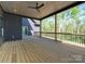 Covered back porch with wood flooring, ceiling fan, and railing overlooking trees at 2008 Plain Field Dr, Bessemer City, NC 28016