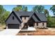 Beautiful front exterior featuring brick and board and batten, a two-car garage, and professional landscaping at 2008 Plain Field Dr, Bessemer City, NC 28016